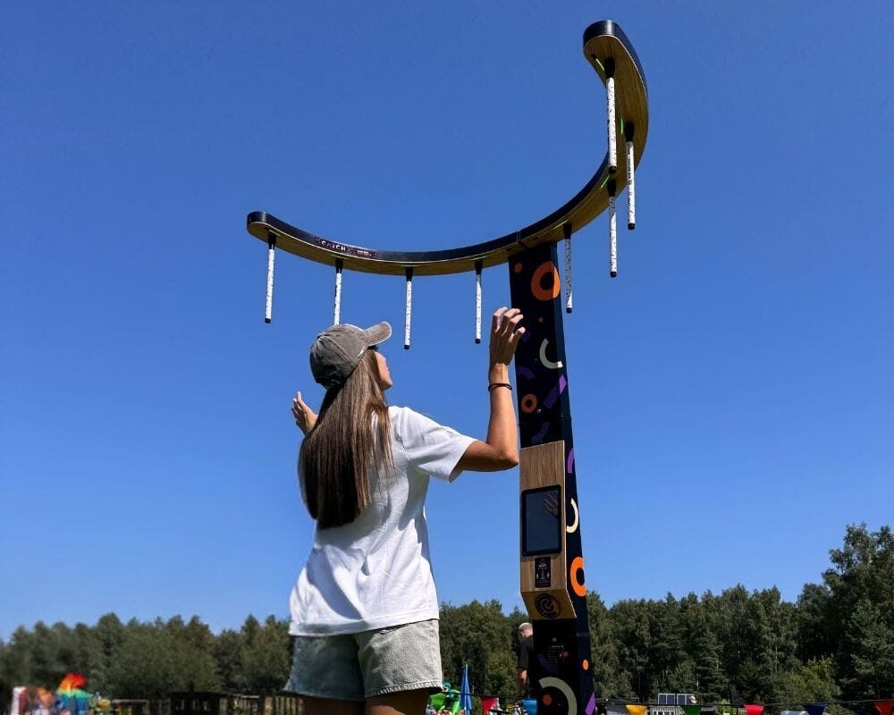A girl playing NODE CATCH game station outside