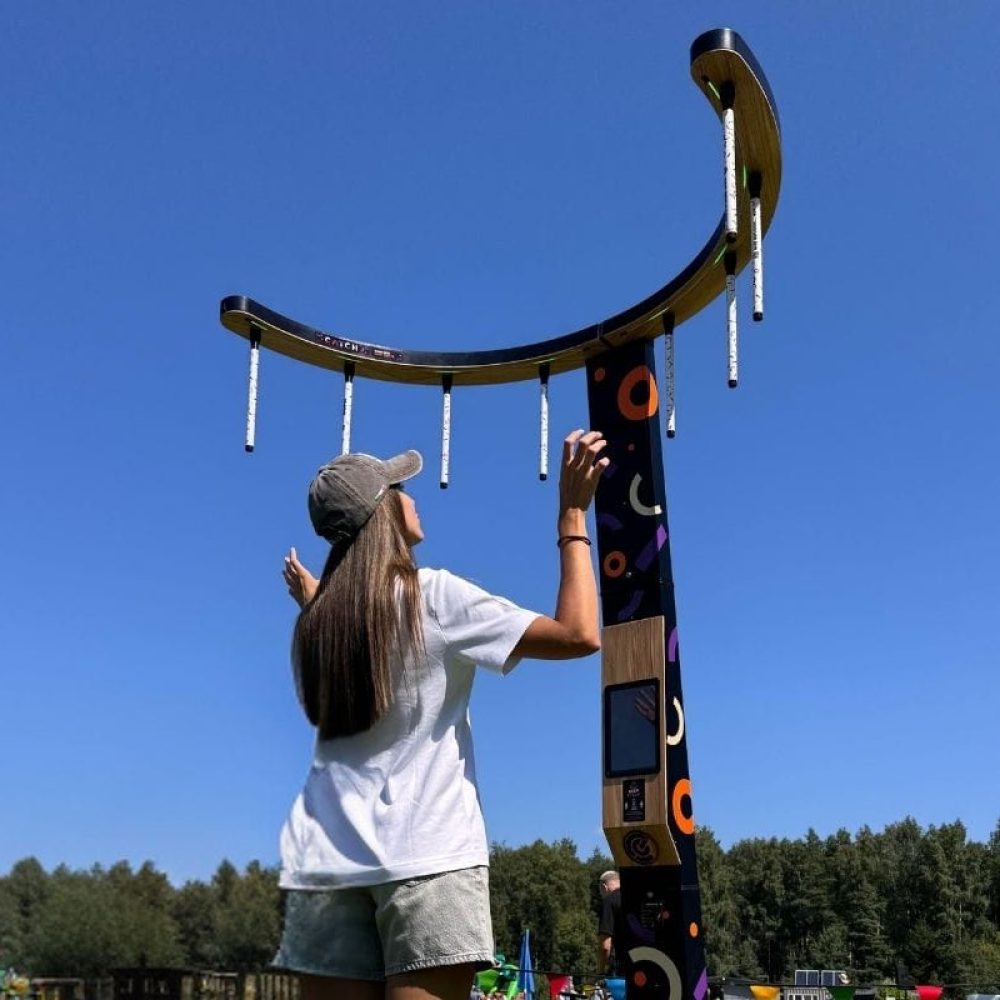 A girl playing NODE CATCH game station outside